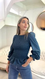 Top fucsia de algodón con elástico en el tronco y puños, mangas largas abullonadas y cuello redondo.