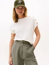 Remera de algodón con cuello redondo, mangas tipo kimono y detalle de botones dorados en el hombro.