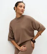 Blusa de punto de corte holgado, con cuello redondo alto y mangas cortas amplias con sisa desplazada. Confeccionada en tejido de punto ligero.