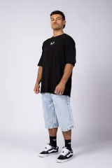 Remera de corte oversize color blanco hueso, con cuello redondo y estampa pequeña centrada en el pecho que presenta dos figuras de caballos alados.