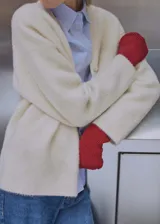 Cardigan de punto con efecto pelo, escote en pico y cierre frontal de botones. Presenta un diseño recto de manga larga con puños acanalados en color rojo contrastante.