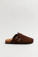 Zueco de gamuza color marrón con puntera cerrada, base anatómica de corcho y detalle de hebilla metálica lateral.
