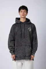 Buzo canguro oversize de algodón friza con efecto de teñido artesanal desgastado. Presenta capucha con cordones negros, bolsillo frontal tipo canguro y estampa pequeña de Popeye en el pecho.