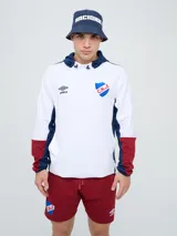Canguro deportivo Umbro del Club Nacional de Football, modelo Evoque. Diseño con bloques de color blanco en el torso, azul en la capucha, laterales y parte superior de las mangas, y rojo en los puños. Incluye capucha con cordón ajustable, logo de Umbro y escudo del club bordados en el pecho.