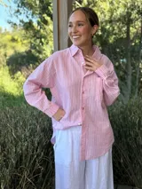 Camisa celeste a rayas verticales blancas, de corte holgado, manga larga y cuello camisero.