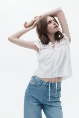 Jean de tiro alto con corte recto y holgado, confeccionado en denim rígido de cinco bolsillos con cierre de botón.