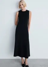 Vestido midi de corte evasé y diseño minimalista, con cuello redondo y sin mangas. Presenta una costura vertical central en el frente y cierre de cremallera en la parte posterior.