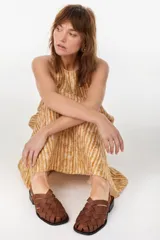 Sandalias de cuero marrón con diseño de tiras trenzadas tipo huarache, punta cuadrada y suela plana con taco bajo.