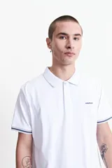 Remera polo color salmón de estilo jersey, corte regular, con logo estampado y detalles en azul marino en cuello y mangas. Confeccionada en algodón y spandex.