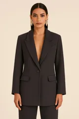 Blazer estructurado negro de crepé con solapas amplias, cierre de un solo botón y bolsillos con solapa en la parte delantera.