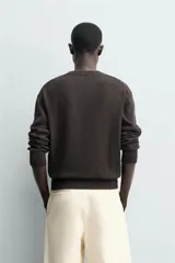 Jersey de punto de corte regular, confeccionado en una mezcla de algodón y lino. Presenta cuello redondo, manga larga y acabados en rib en cuello, puños y bajo.