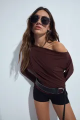 Top de manga larga color marrón chocolate, con escote amplio tipo bote que permite llevarlo caído sobre los hombros. Presenta un diseño entallado de tejido liso y liviano.