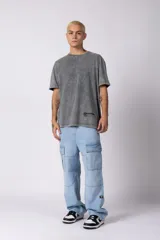 Jean cargo de corte baggy y tiro medio, confeccionado en denim de color celeste con lavado soft. Presenta bolsillos laterales tipo cargo con solapa, costuras reforzadas en las rodillas y un calce holgado con caída relajada.