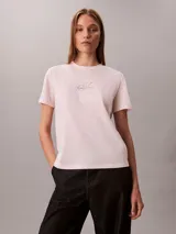 Remera Calvin Klein de manga corta y corte regular, color rosado, con cuello redondo y el logo de la marca impreso en el pecho con efecto metalizado.