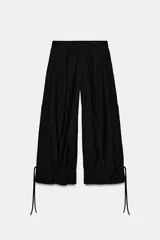 Pantalón de tiro medio con diseño cargo, confeccionado en tejido con mezcla de lana. Presenta bolsillos laterales de plastrón y bajo abullonado ajustable mediante lazadas. Cierre frontal con cremallera, botón y ganchos metálicos.