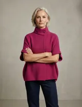 Capa tejida color fucsia, con cuello alto abotonado y mangas cortas estilo japonesa. Tejido de punto grueso.