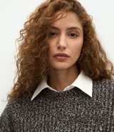 Suéter de punto con efecto mezclado, cuello redondo y mangas largas. Presenta un corte regular over con estructura encorpada.