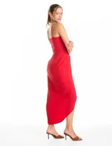 Vestido midi de crepe color rojo, con escote en V cruzado y drapeado en el busto. Presenta una falda envolvente con diseño drapeado que genera una abertura asimétrica en el bajo. Cuenta con tirantes finos y cierre invisible en la espalda.