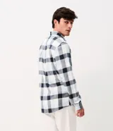Camisa de corte comfort confeccionada en algodón, con estampado de cuadros en tonos marrón, beige y azul. Presenta cuello camisero, mangas largas con puños abotonados y cierre frontal con botones.