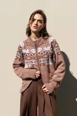 Cardigan tejido de algodón con cierre frontal doble, cuello alto y diseño de motivos abstractos en tonos marrones y celestes. Presenta un corte relajado y boxy con puños y ruedo acanalados.