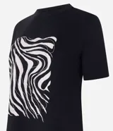 Remera de algodón color negro con cuello redondo y mangas cortas. Presenta una estampa frontal abstracta con líneas onduladas en tonos claros.