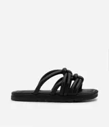 Sandalia plana de color negro con diseño de tiras tubulares acolchadas tipo puffer entrelazadas con nudos. Presenta puntera redonda, plantilla anatómica y suela de goma al tono.