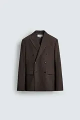 Blazer cruzada regular fit confeccionada en tejido con mezcla de lana y algodón, en color marrón. Cuenta con solapas de pico, manga larga, bolsillos con solapa en la cadera y cierre frontal de botonadura doble.