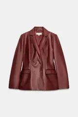 Blazer cruzado de efecto piel color bordó, con solapas de muesca, mangas largas y bolsillos con solapa en la parte delantera. Cierre frontal con botones a tono.