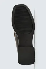 Mocasín de vestir color marrón oscuro, con empeine liso y detalle de antifaz. Presenta horma cuadrada y suela con ligero tacón geométrico a contraste.