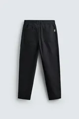 Pantalón de corte carrot fit confeccionado en tejido de algodón con estructura diagonal y efecto lavado. Presenta bolsillos frontales con bolsillo cerillero, bolsillos traseros de plastrón y cierre frontal con cremallera y botón.