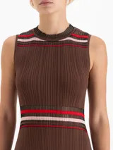 Vestido midi de punto sin mangas con diseño plisado. Presenta un corte evasé con rayas horizontales en tonos rojo, rosa y negro en el cuello, la cintura y el ruedo, el cual cuenta con terminaciones irregulares y detalles de transparencia.