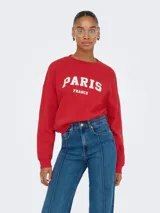 Buzo rojo de manga larga con cuello redondo y puños acanalados. Presenta un fit holgado y un largo corto, con estampado frontal que dice "PARIS FRANCE" en blanco.