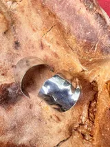 Aros metálicos grandes con forma ondulada, color plateado.