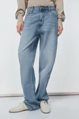 Pantalón de jean celeste de tiro alto, corte recto y largo hasta el tobillo. Tiene cinco bolsillos, trabillas en la cintura, efecto lavado y cierre frontal con cremallera y botón.