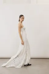Vestido largo de encaje blanco con tirantes finos y silueta ajustada.