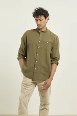 Camisa de cuello mao y manga larga, confeccionada en una mezcla de lino y algodón. Presenta un diseño de corte recto con botones en tono natural y un bolsillo pequeño en el pecho.