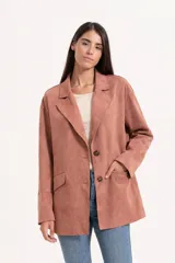 Blazer de estilo oversize confeccionado en material simil gamuza, con cuello solapa, cierre frontal de dos botones y bolsillos laterales con solapa.