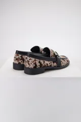 Mocasines de cuero con estampado animal print, detalle de hebilla plateada y suela plana.