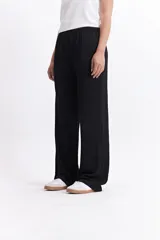 Pantalón de vestir de tiro alto, color crema, con textura crepe arrugada y pierna ancha y fluida. Presenta cintura elástica.