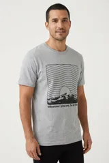 Remera de manga corta color gris melange, con cuello redondo y estampa frontal en negro de un paisaje de montaña con líneas onduladas y la inscripción "wherever you are, be all there".