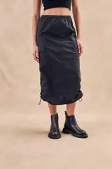 Falda midi negra estilo parachute, con cintura elástica, bolsillos laterales tipo cargo y cordones ajustables en el ruedo.