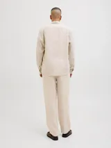 Pantalón chino de lino color beige, corte clásico, con cierre de cremallera y cintura con elástico.