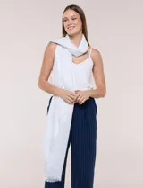 Pashmina de gasa blanca con sutil brillo metalizado, diseño rectangular de gran tamaño y terminación desflecada en los extremos.