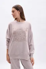 Buzo oversize color beige con cuello redondo y estampado frontal de flores y la inscripción "LES JARDINS 63".