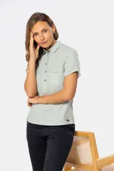 Camisa de lino de manga corta con cuello camisero, cierre frontal de medio botón con botones metálicos personalizados y dos bolsillos en el pecho.