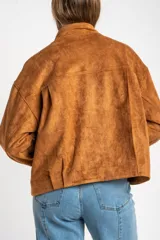 Campera tipo bomber de gamuza sintética color camel, con cierre frontal, cuello alto y diseño oversize.