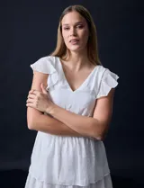 Vestido blanco de gasa con capas, marca Julia Jordan. Escote en V, manga corta con volados, corte en cintura y abertura central en espalda con cierre invisible.