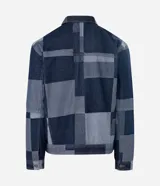 Campera de jacquard de algodón con diseño patchwork de cuadros en tonos azules. Presenta cuello inglés, cierre frontal con botones metálicos, mangas largas y bolsillos delanteros.