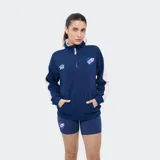 Buzo deportivo azul marino con medio cierre frontal, cuello alto y bandas rosadas en las mangas. Presenta el logo de Umbro y el escudo del Club Nacional de Football bordados en el pecho, además de un bolsillo tipo canguro.