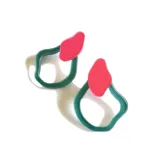 Par de aros con diseño abstracto, con forma geométrica irregular en color verde y detalle superior en color rosa.